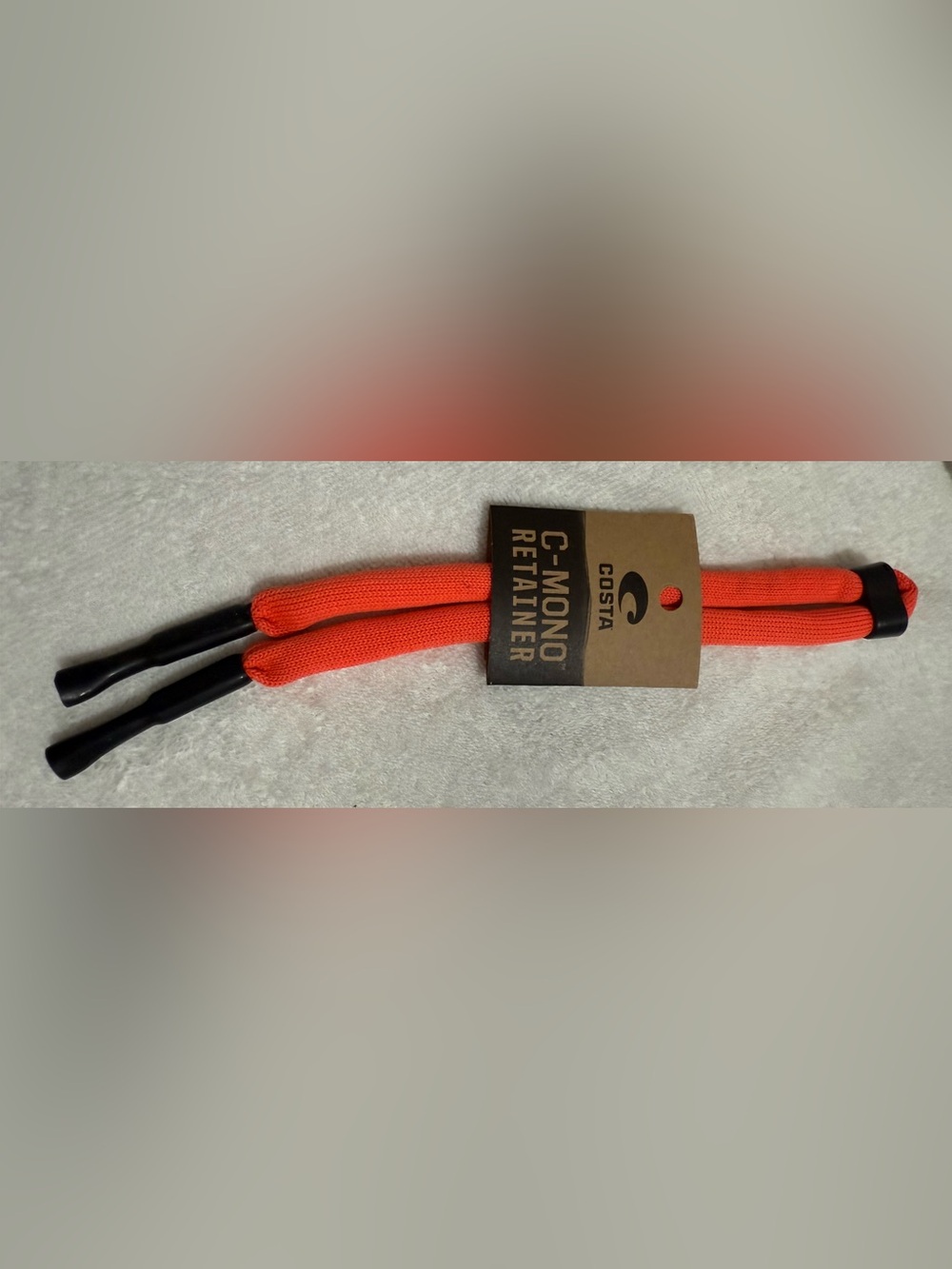 Costa eyewear retainer in bright orange with black accents